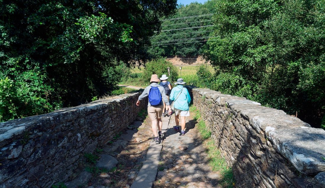 Cross the medieval bridge into Portomarín.